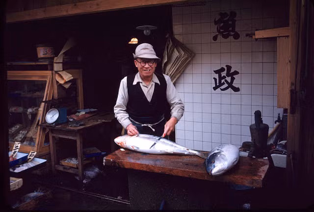 Người đàn ông "xẻ thịt" cá bán cho khách hàng.