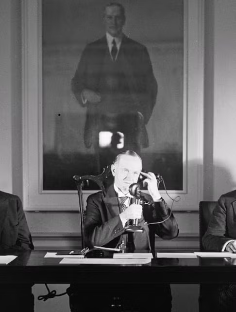 Tổng thống thứ 30 của Mỹ Calvin Coolidge gọi điện qua điện thoại năm 1928. Bên cạnh ông là nhiều quan chức trong chính quyền.