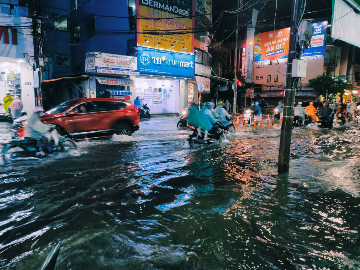 Tuy chưa ngập sâu bằng đường Lê Duẩn, tại đây nước cũng đã tràn lên vỉa hè.