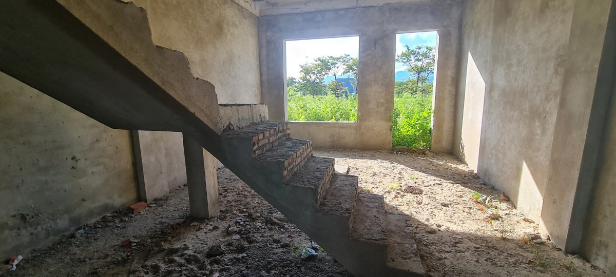 Cầu thang được đặt ở cuối căn nhà, bên ngoài là cỏ dại ngập lối, thò vào tận cửa sau.