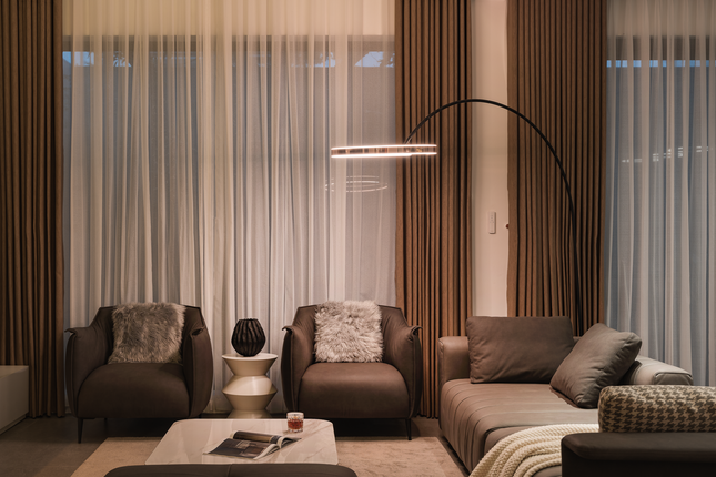 Việc thiết kế đẩy không gian bếp ăn về phía sau cũng tạo ra không gian riêng tư cho gia đình, giúp mỗi thành viên có thể tận hưởng khoảng thời gian riêng của mình mà không ảnh hưởng đến những hoạt động chung. Những chiếc ghế sofa bọc da đắt tiền là nơi thư giãn mỗi buổi tối của gia đình.