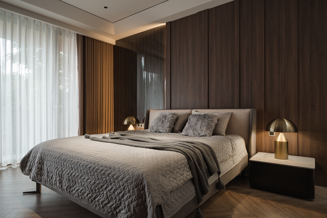 Phòng ngủ rộng rãi, với tông màu chủ yếu là màu nâu đất và màu ghi, khiến không gian thêm trầm lắng.