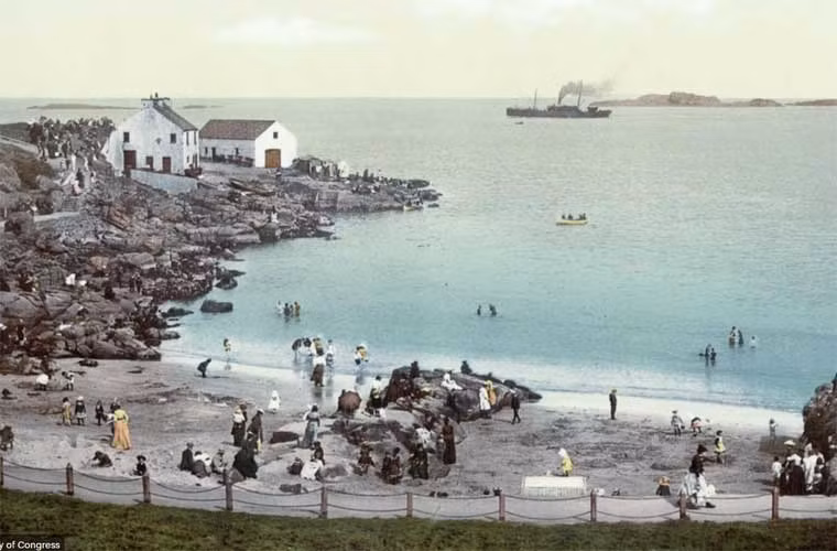 Khách du lịch đang thong dong rảo bước bên bờ biển Portrush vào một ngày nắng đẹp.