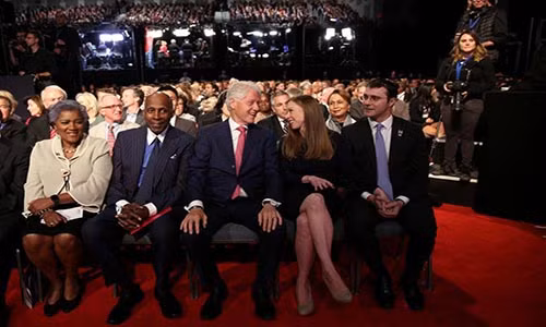 Gia đình của bà Hillary Clinton ngồi hàng ghế đầu ở khu vực dành cho khán giả. Trong ảnh, cựu Tổng thống Mỹ Bill Clinton (ngồi giữa, hàng đầu) trò chuyện với con gái, Chelsea Clinton, trước cuộc tranh luận đầu tiên trên truyền hình của hai ứng viên tổng thống Mỹ Hillary Clinton và Donald Trump.