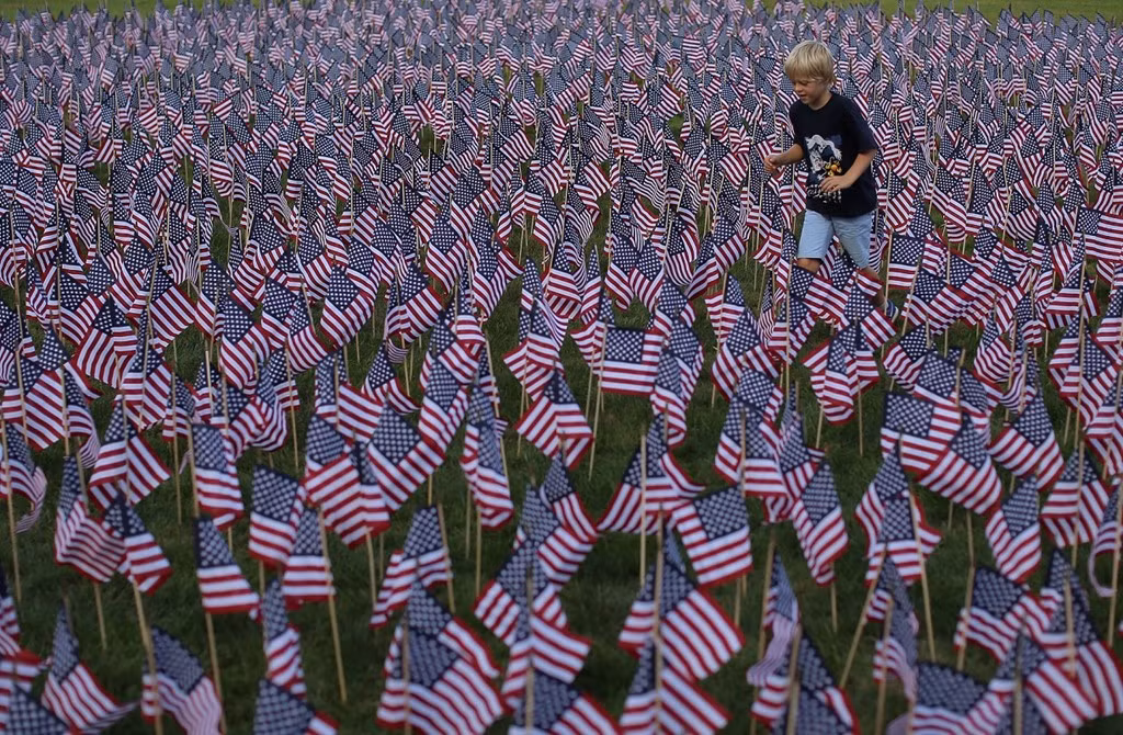 Cậu bé George Betsill đi qua khu vực cắm khoảng 3.000 lá cờ cắm ở công viên Winnetka, bang Illinois, tương ứng với số nạn nhân thiệt mạng do vụ không tặc ngày 11/9 gây ra.