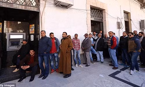 Những người dân Lybia dù không ưa Đại tá Muammar Gaddafi cũng cho rằng cuộc sống dưới thời nhà độc tài này tốt đẹp hơn so với hiện tại. Được biết, nhà độc tài Muammar Gaddafi đã bị lật đổ và giết hại vào năm 2011 sau 42 năm cầm quyền. Ảnh: Người dân ở Tripoli xếp hàng chờ rút tiền tại một cây ATM.