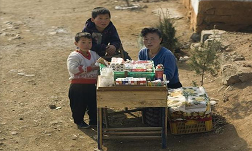 Người phụ nữ Triều Tiên đang ngồi bán hàng bên vệ đường.