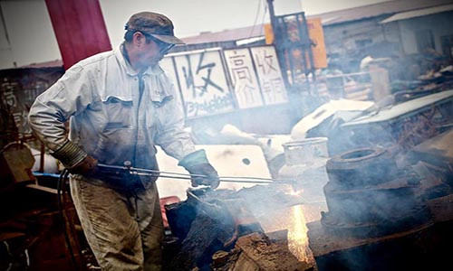 Một công nhân làm việc tại nhà máy phế liệu ở thành phố Phủ Thuận, tỉnh Liêu Ninh. Do giá thép trên thế giới sụt giảm, nhiều công nhân đã bị sa thải hoặc chỉ được làm việc bán thời gian.