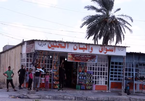 Nhiều người dân Iraq tập trung trước một cửa hàng ở huyện Qayyarah sau giải phóng.