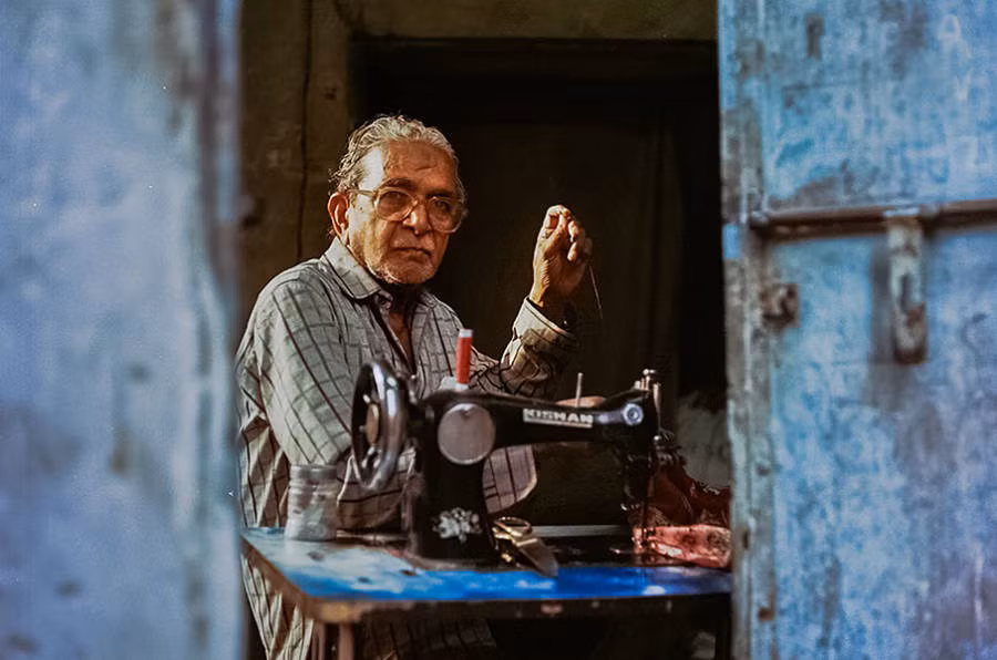 Thợ may Abdul Hakim, 75 tuổi, đang làm việc trong tiệm may của ông.