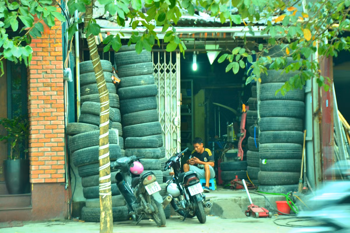 Ngôi nhà cấp 4 lụp xụp với những hàng lốp xe xếp cao đến mái.