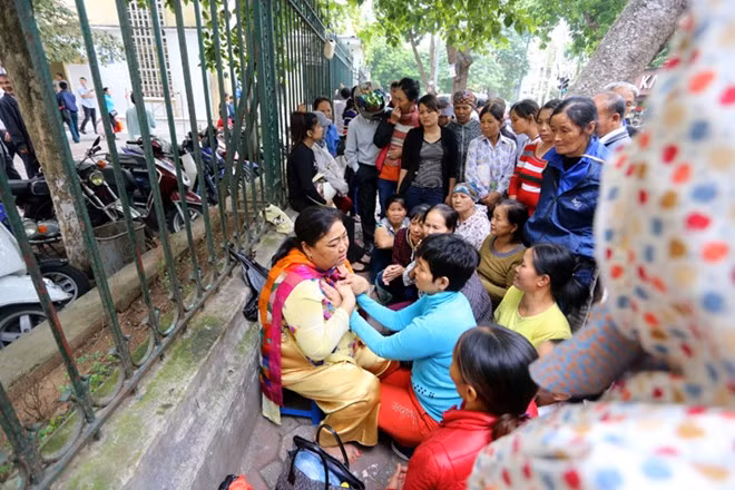 Người dân chăm chú theo dõi và nuốt từng lời phán của "thánh chữa bệnh". Thậm chí có lúc bà ta còn cầm cả hai tay người bệnh úp vào ngực mình để "truyền năng lượng".