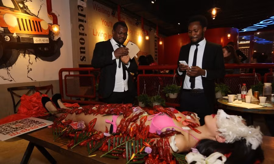 Hai du khách nước ngoài đến gần bàn tiệc tôm đặc biệt.