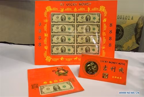 Những tờ tiền 1 USD may mắn sẽ được kẹp trong thiệp đỏ có hình một chú khỉ vàng cầm trái đào và những câu chúc bằng tiếng Trung Quốc được làm từ lá vàng dát mỏng.