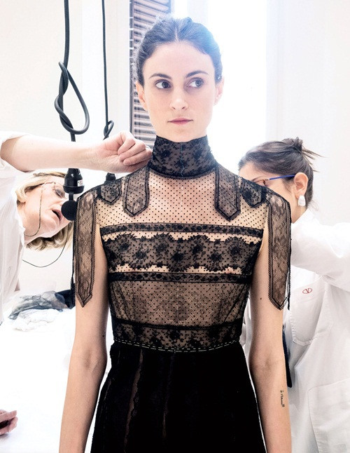 Hai người thợ may của Valetino đang ráp một bộ đầm thêu ren và đăng ten trên người mẫu thử đồ.