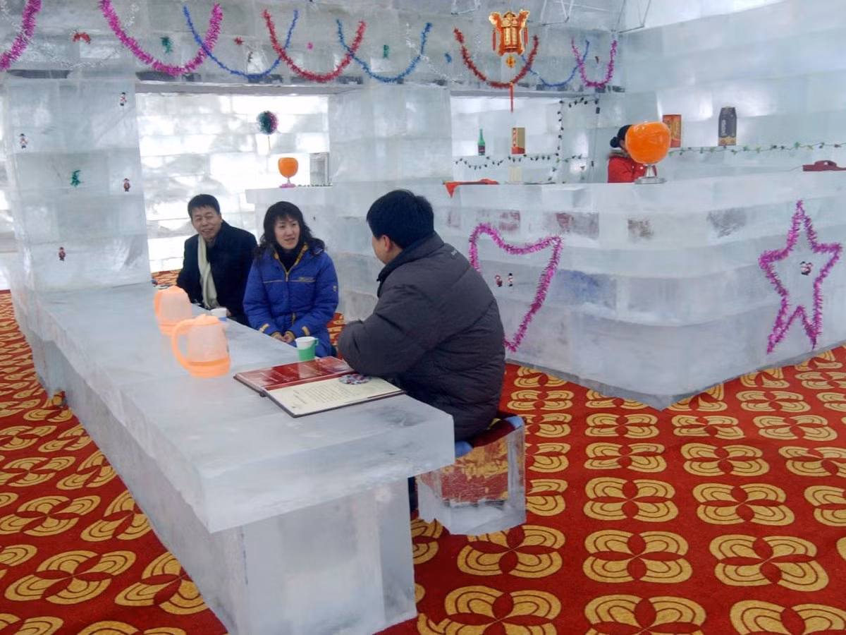 Thực khách ngồi bên trong một nhà hàng làm bằng băng tại Cáp Nhĩ Tân, Trung Quốc. Nhà hàng băng đá đặc biệt này có thể tiếp đón khoảng 100 khách hàng cùng một lúc.