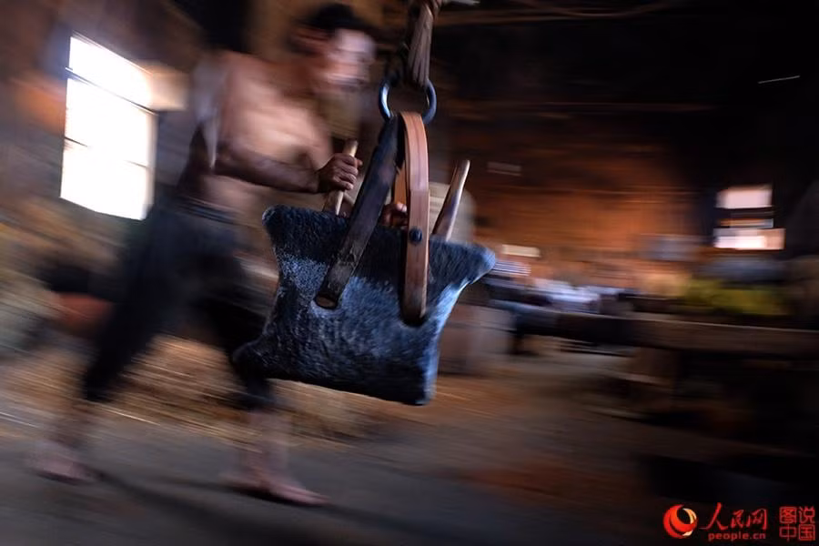 Công việc ép dầu lấy đi nhiều công sức của người công nhân.