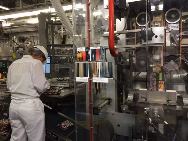 Jackie Bailie, một nhân viên của công ty, đang kiểm tra các túi kẹo để xem có điểm khiếm khuyết nào không.