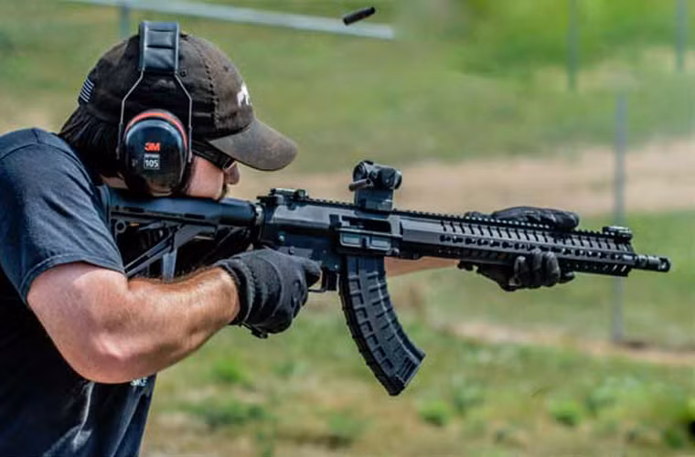 Báng sử dụng loại báng đồng trục có thể chỉnh độ dài ngắn tùy theo xạ thủ, đây vốn là loại báng từng xuất hiện nhiều trên một số dòng súng cải tiến từ M16 của Mỹ. Loại báng này được đánh giá cao hơn báng của AK-47 khi nó có thể hấp thụ theo phương ngang của lực giật giúp súng không bị nảy lên như AK-47.