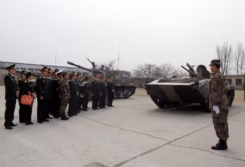 Đoàn Việt Nam nghe giới thiệu về những chiếc xe tăng, xe chiến đấu bộ binh, pháo tự hành gắn liền với truyền thống của Sư đoàn 6 Tăng thiết giáp.