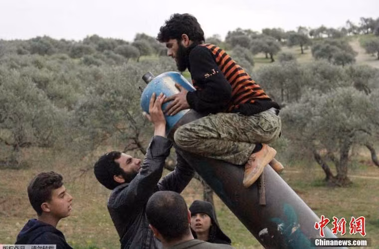 Bức ảnh quân sự hài hước nhất tuần – vì kích cỡ quả đạn cối tự chế quá lớn khiến một chiến binh quân nổi dậy Syria phải leo lên tận đầu nòng cỗ pháo cối “khủng” để nạp đạn.