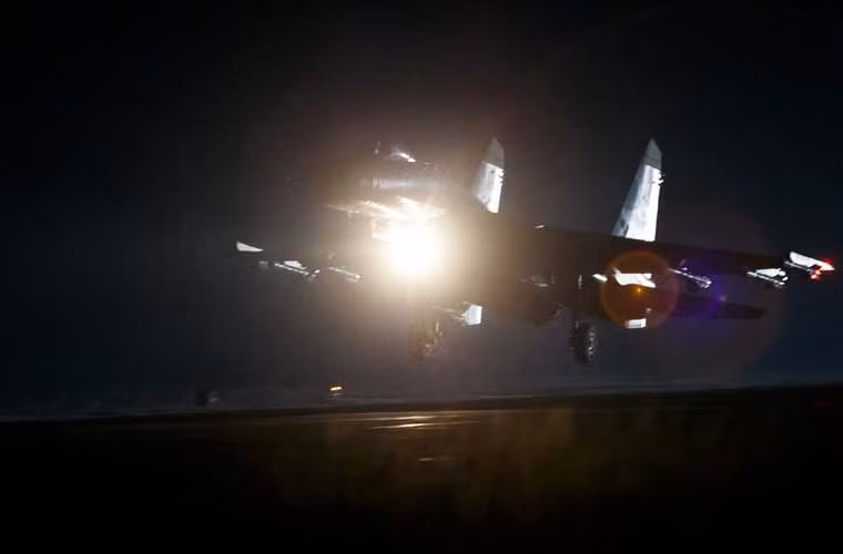 Hình ảnh đẹp máy bay tiêm kích đa năng Su-35 bật đèn pha cất cánh trong đêm tối.