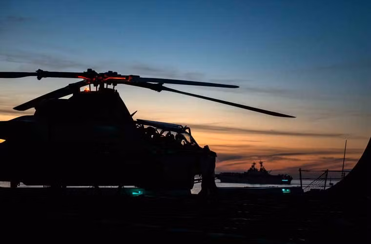 Bức ảnh đẹp chụp ngược sáng trực thăng tấn công AH-1 đậu trên boong tàu đổ bộ lớn USS Anchorage (LPD-23).