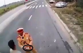 Một cảnh sát giao thông bị cho là nhận tiền mãi lộ trên quốc lộ 21. Ảnh cắt từ clip.