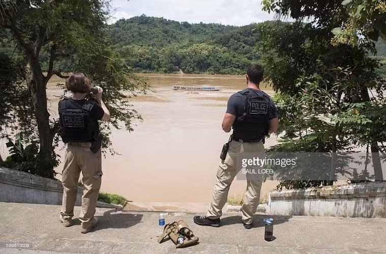 Hai mật vụ Mỹ đang ngắm dòng sông Mekong chảy qua địa phận cố đô Luang Prabang trong lúc ông chủ Nhà Trắng viếng thăm chùa cổ Wat Xieng Thong.