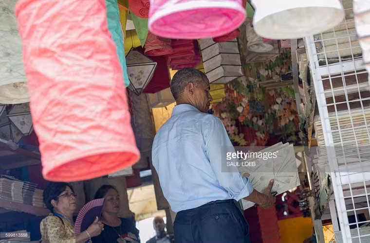 Ông Obama đang tự mình chọn những món quà lưu niệm tại một cửa hàng ở Luang Prabang.