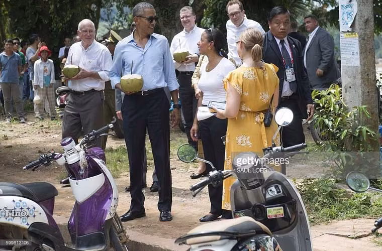 Ông Obama uống nước dừa với Đại sứ Mỹ ở Lào Daniel Clune (bên trái) trong lúc đi bộ ngắm nhìn dòng sông Mekong chạy qua địa phận Luang Prabang.