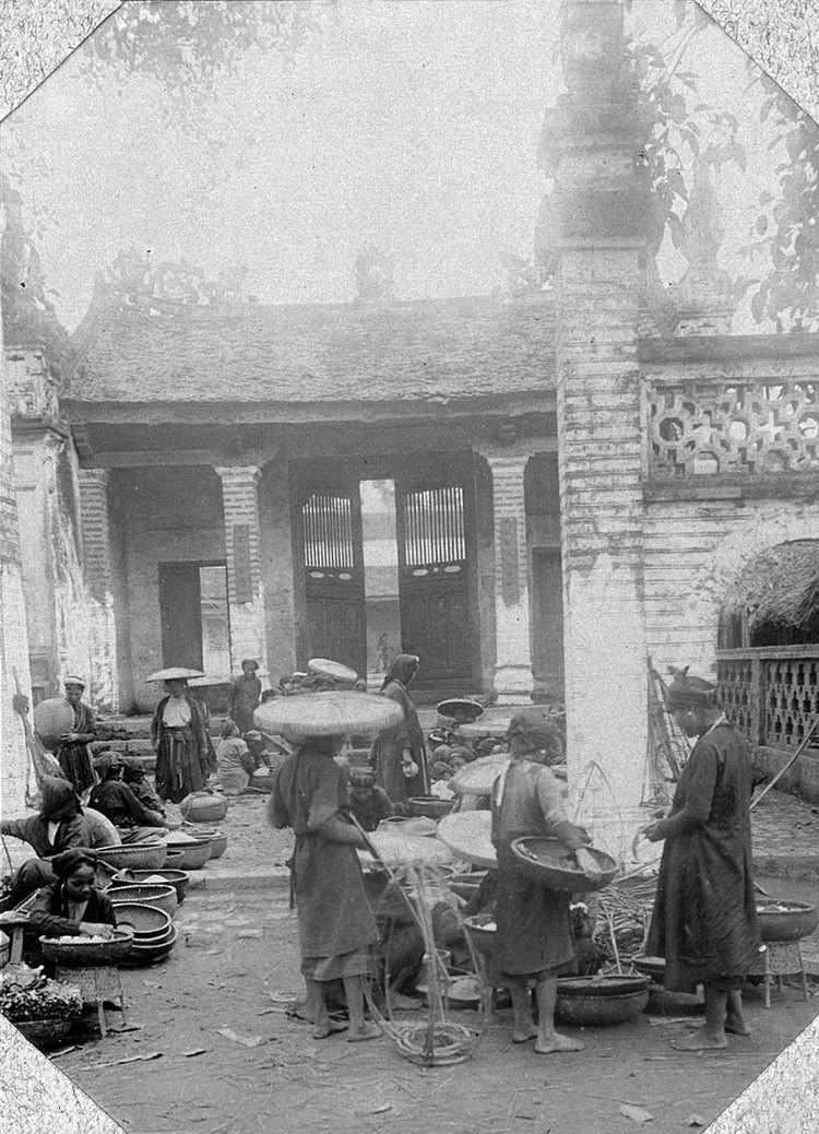 Họp chợ trước cổng một ngôi đền ở làng Giấy (làng Bưởi), Hà Nội.