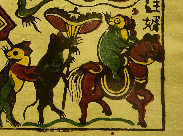 Dẫn đầu là con chuột đực, đầu đội mũ cánh chuồn, mình mặc áo thụng xanh, chân đi hia. Ngồi trên lưng con ngựa hồng, dáng vẻ thư thái, trái ngược điệu bộ e dè của những con chuột còn lại. Đây là một con chuột thành đạt, vừa đỗ tiến sĩ lại cưới được vợ đẹp.