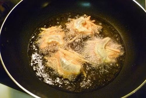 Bước 5: Đặt chảo lên bếp, cho dầu vào, chờ cho dầu sôi thì lấy bàn xản xếp khoai đan lên nhau, đặt tôm lên mặt khoai rồi cho vào chảo rán vàng.