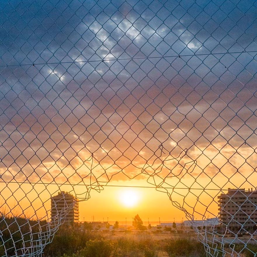 Hàng rào thép bị rách đúng chỗ, giống như chứa cả một bầu trời phía xa. (Nguồn Bored Panda)