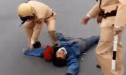 Người đàn ông nằm lăn lộn trên đường sau khi bị CSGT dừng xe vì vượt đèn đỏ.