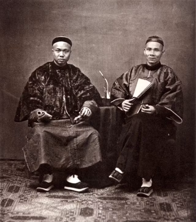 Hai thương nhân nhà Thanh trong trang phục sang trọng.