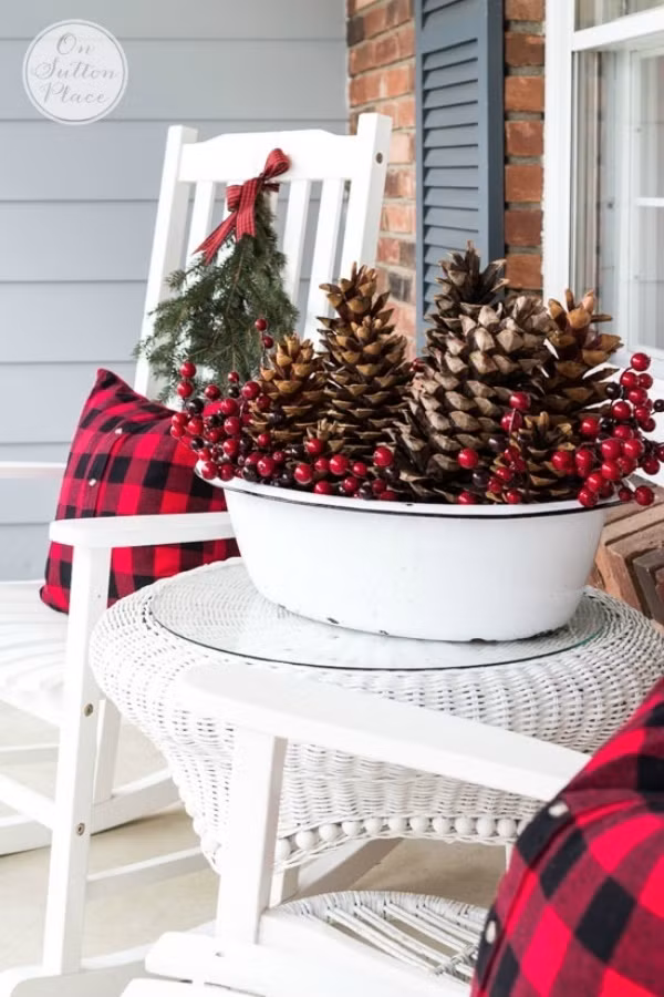 Chỉ cần chọn lựa một vài quả thông, đặt cùng những bông hoa màu đỏ. Thêm vỏ gối cùng tông màu giúp bàn trà ngoài hiên nhà buổi sáng thêm nồng nàn màu sắc Giáng sinh.