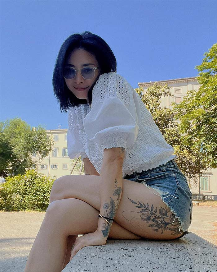 Sơ mi trắng tay bồng điệu đà, quần short ngắn để lộ hình xăm, Ngô Thanh Vân tươi tắn dạo phố.