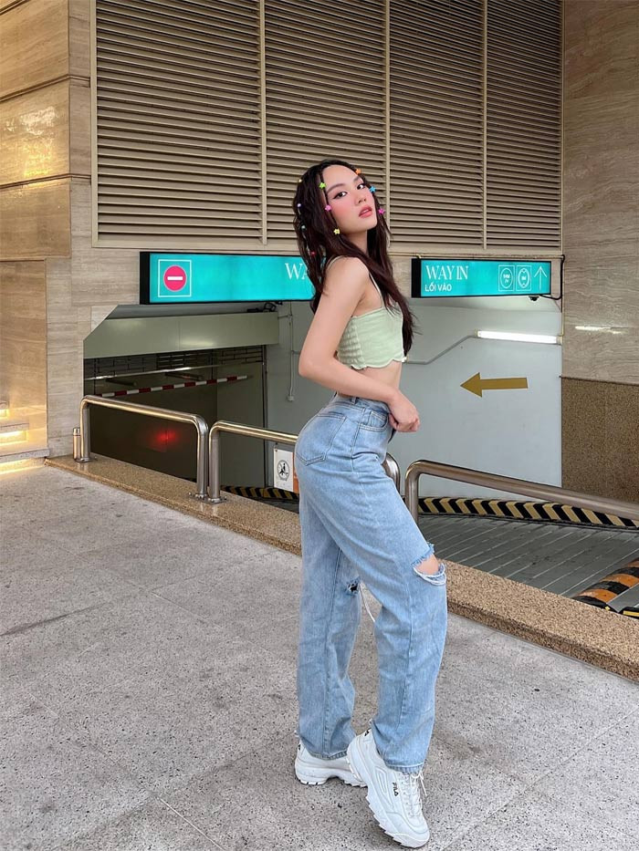 Mai Phương bụi bặm với quần jeans rách gối ống rộng kết hợp với áo ống và đôi giày thể thao.