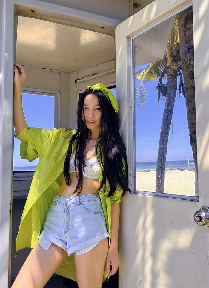 Áo bra trắng, khoác ngoài là sơ mi xanh lá kết hợp cùng quần short jeans xanh nhạt, tóc điểm thêm chiếc nơ cùng màu áo sơ mi, nhìn Hiền Thục rực rỡ và tràn đầy sức sống.