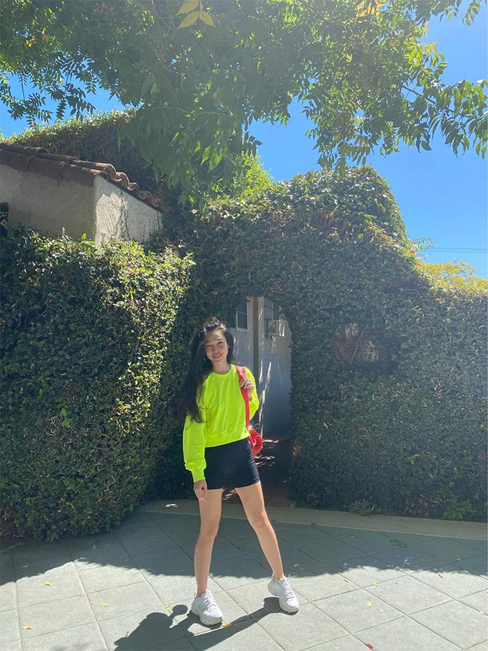 Quần short đen kết hợp với áo thun dài tay nõn chuối và phụ kiện là chiếc túi đỏ, đôi giày thể thao màu trắng, bộ cánh của Hiền Thục đơn giản nhưng lại có hiệu ứng trẻ trung tối đa.