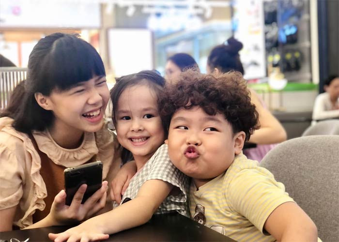 Cô bé chơi đùa, cười tươi cùng hai anh chị diễn viên nhí rất tự nhiên.