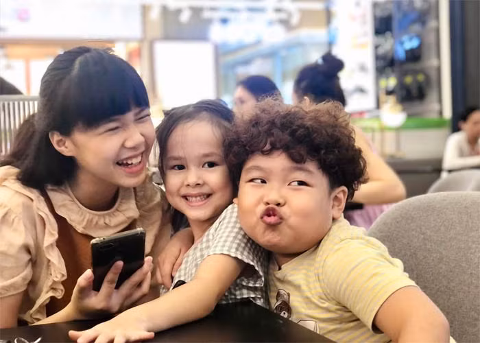 Cô bé chơi đùa, cười tươi cùng hai anh chị diễn viên nhí rất tự nhiên.