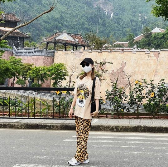 Áo phông rộng kết hợp với quần suông hoạ tiết da báo, kính đen và mũ lưỡi trai, nữ ca sĩ quê Bình Định tạo diện mạo mới lạ trong một chuyến đi chơi.