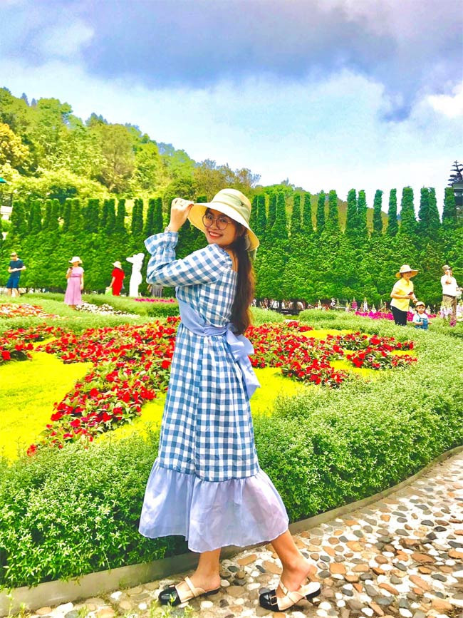 Nữ ca sĩ sinh năm 2002 chọn váy kẻ caro xanh, dài trong một chuyến du lịch.