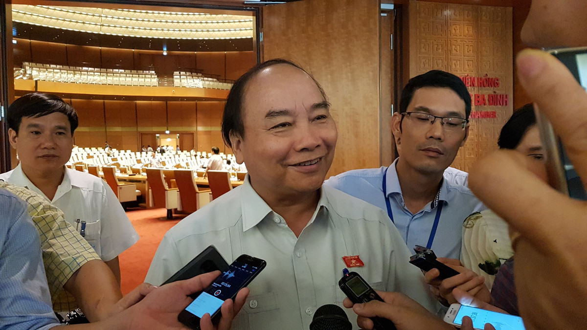 Thủ tướng trao đổi với báo chí bên hành lang Quốc hội.