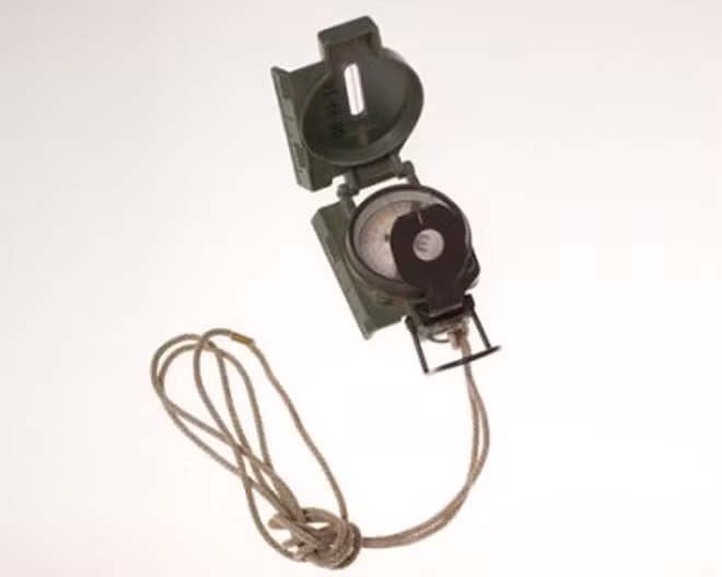 La bàn được trang bị thêm kính lúp phía dưới giúp điệp viên phóng to ký tự siêu nhỏ khi làm nhiệm vụ. Thiết bị này có vỏ được chế tạo từ nhôm và kim phản quang có độ chính xác cao.