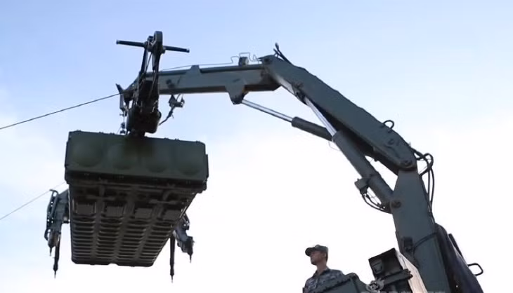 Xe nạp đạn tổ hợp đang thực hiện cẩu module đạn lên bệ phóng.