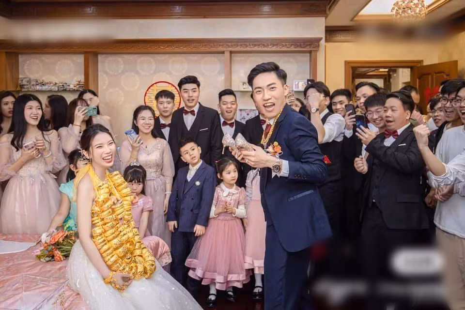 Không kém cạnh vợ, chú rể cũng được trao hàng chục sợi dây chuyền vàng đeo trên cổ kèm theo loạt nhẫn vàng rực rỡ.
